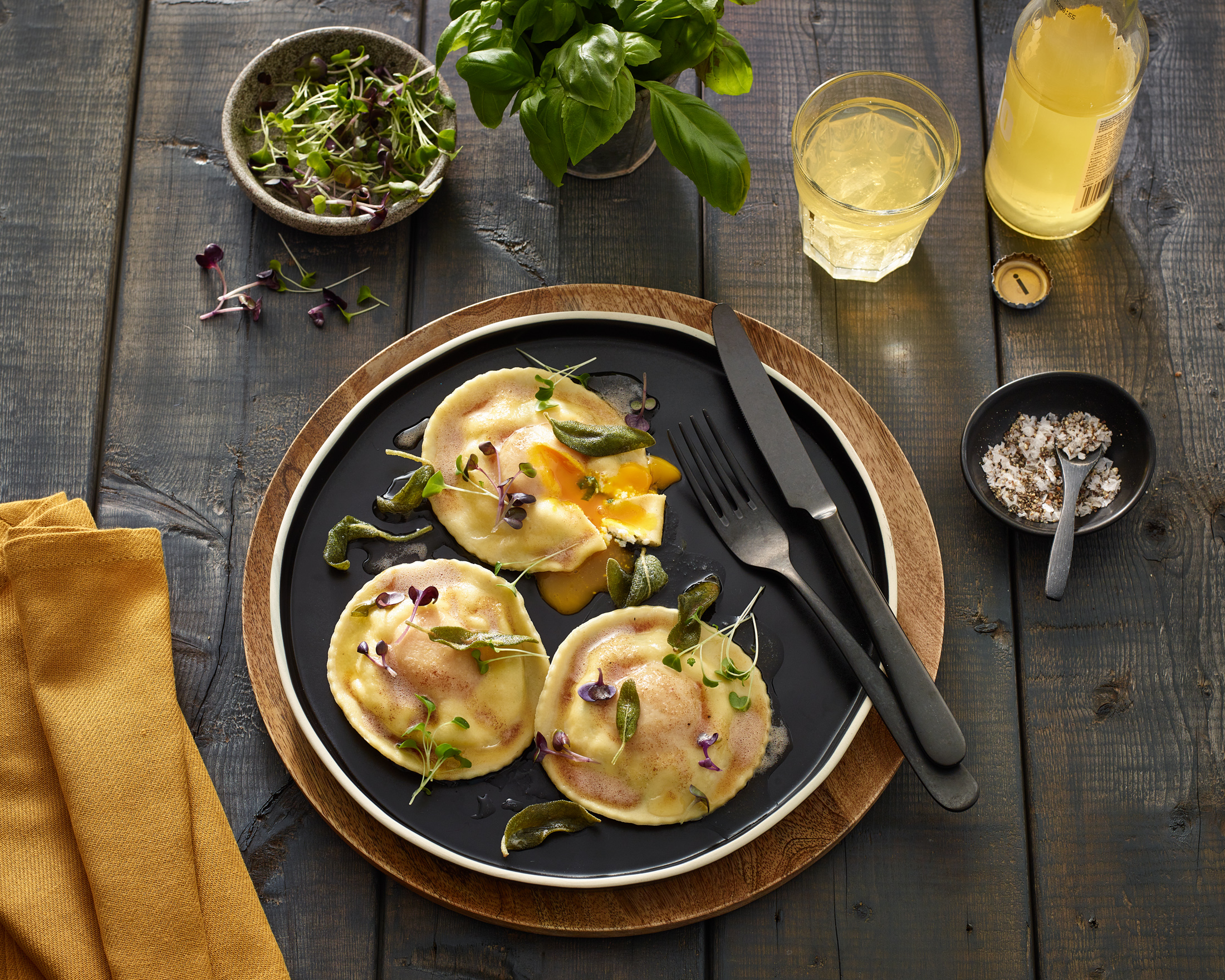 Gourmet ravioli dish with garnish on wooden table.