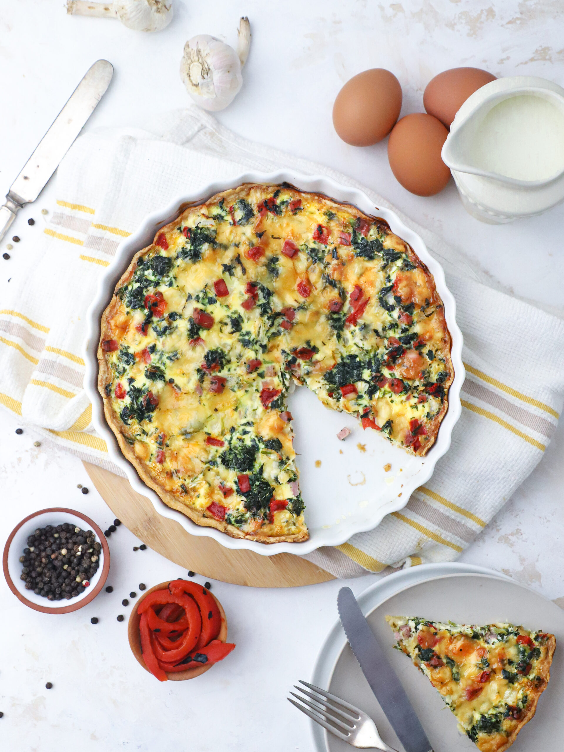 Homemade spinach and tomato quiche on table