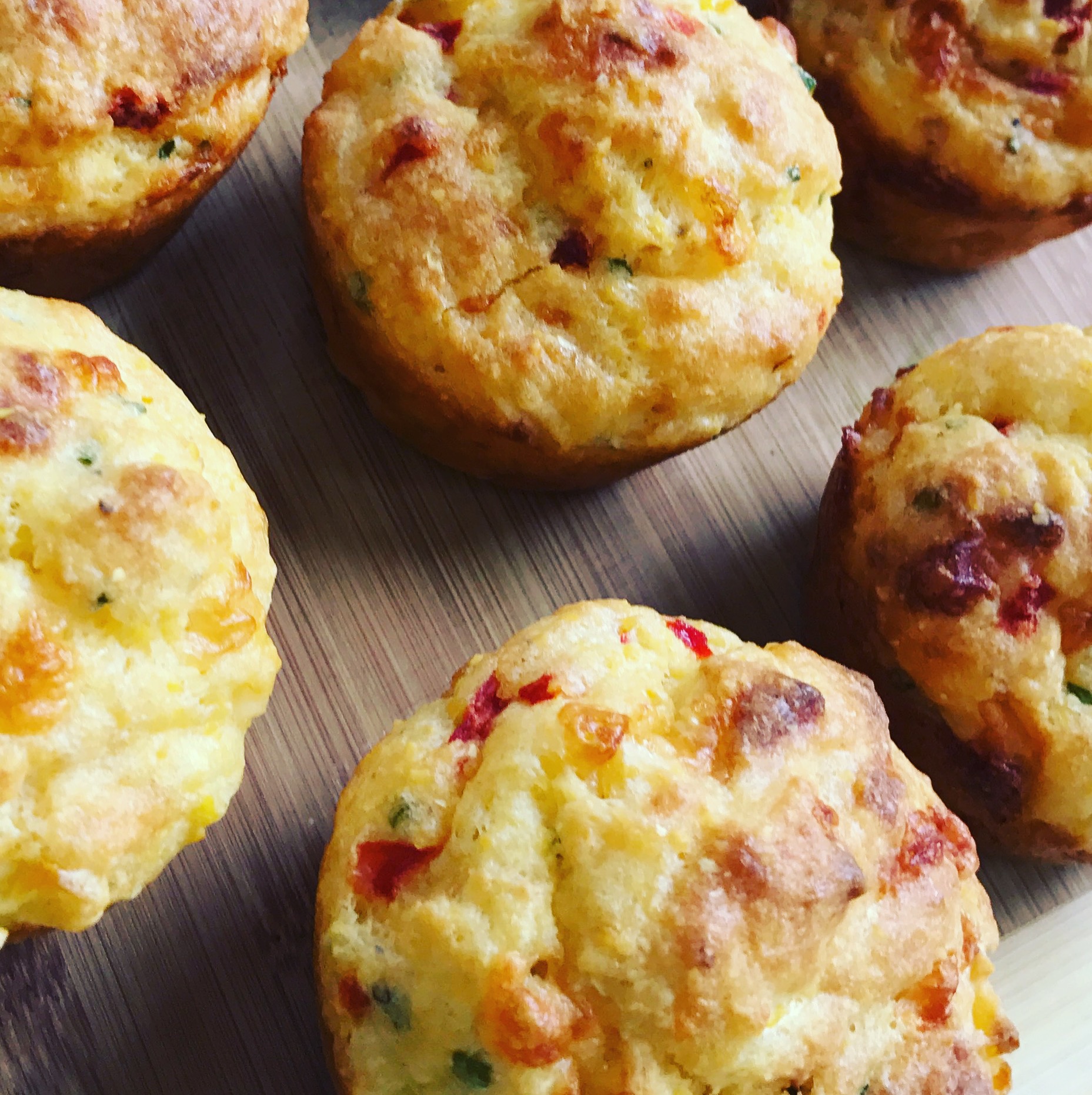 Fresh baked savory breakfast muffins on wooden board