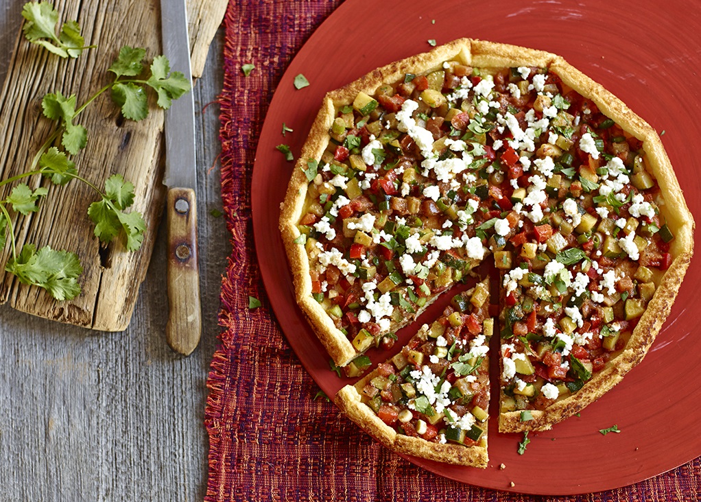 Fresh vegetable quiche on red plate wooden table